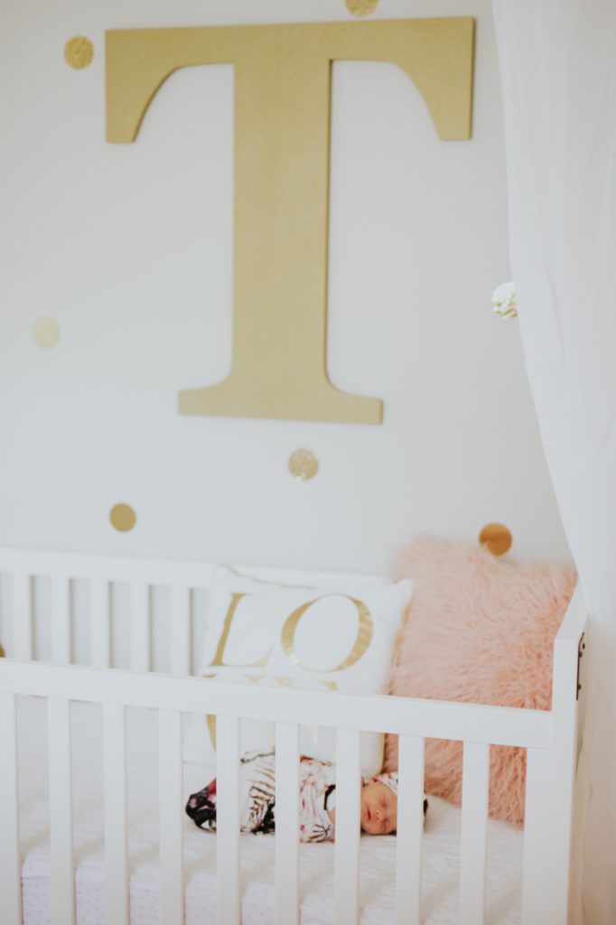 gold letter t over the top of a white crib with sleeping baby for Noblesville Newborn Photography
