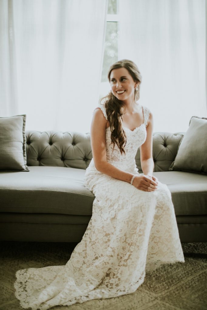 bride sits on antique sofa in wedding dress at mustard seed gardens for Noblesville Wedding Photography