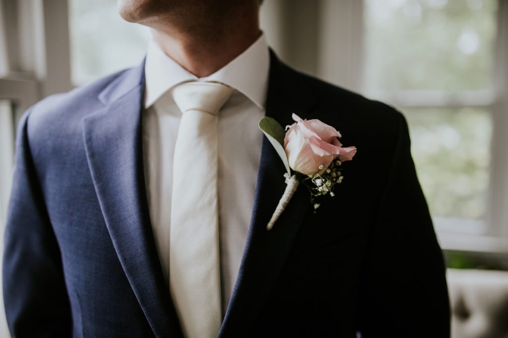 boutonniere on blue suit at mustard seed gardens