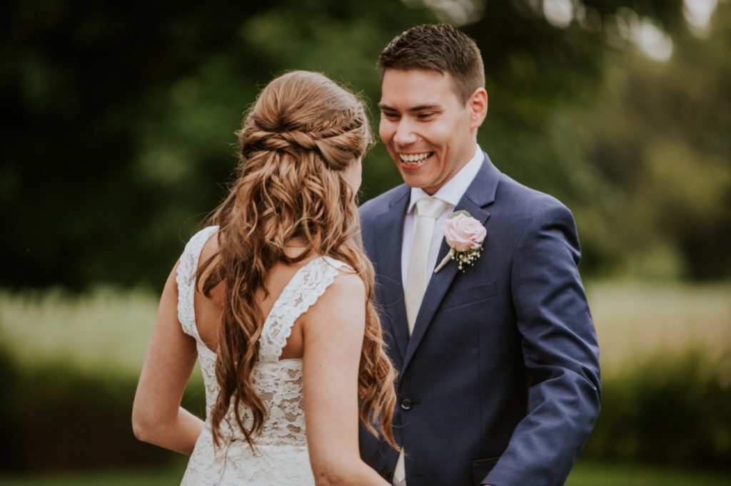 groom smiles as he looks at bride at mustard seed gardens for Noblesville Wedding Photography
