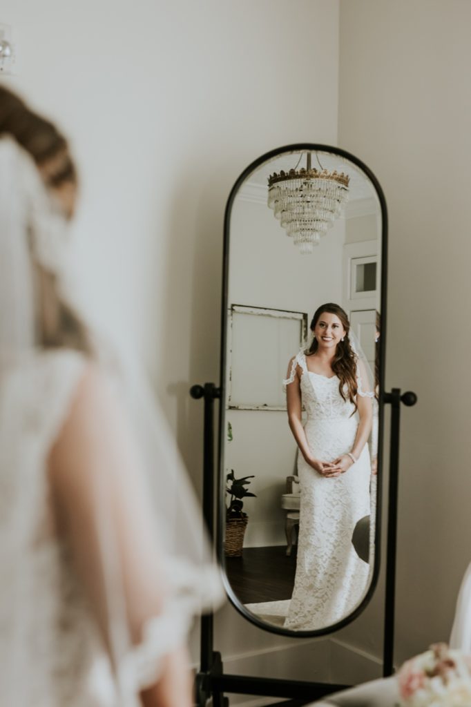 bride looks in mirror at herself at mustard seed gardens