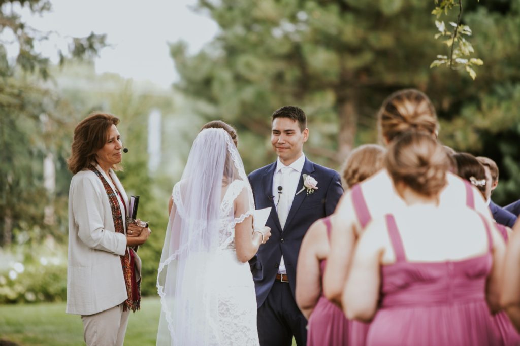 groom smiles as bride reads vows for Noblesville Wedding Photography