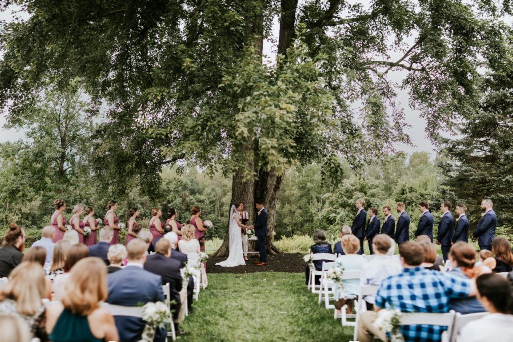 wedding outside under a giant tree at mustard seed gardens