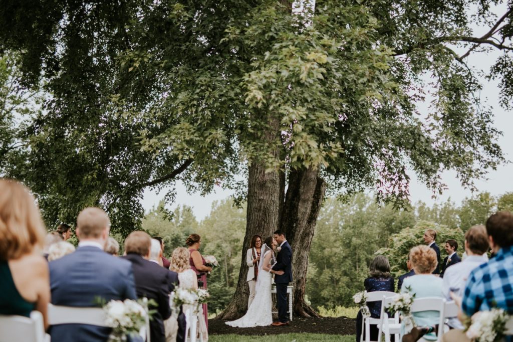 bride and groom kiss under tree at wedding ceremony for first time for Noblesville Wedding Photography