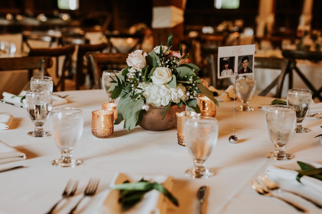 floral centerpiece with golden accents and candles at mustard seed gardens