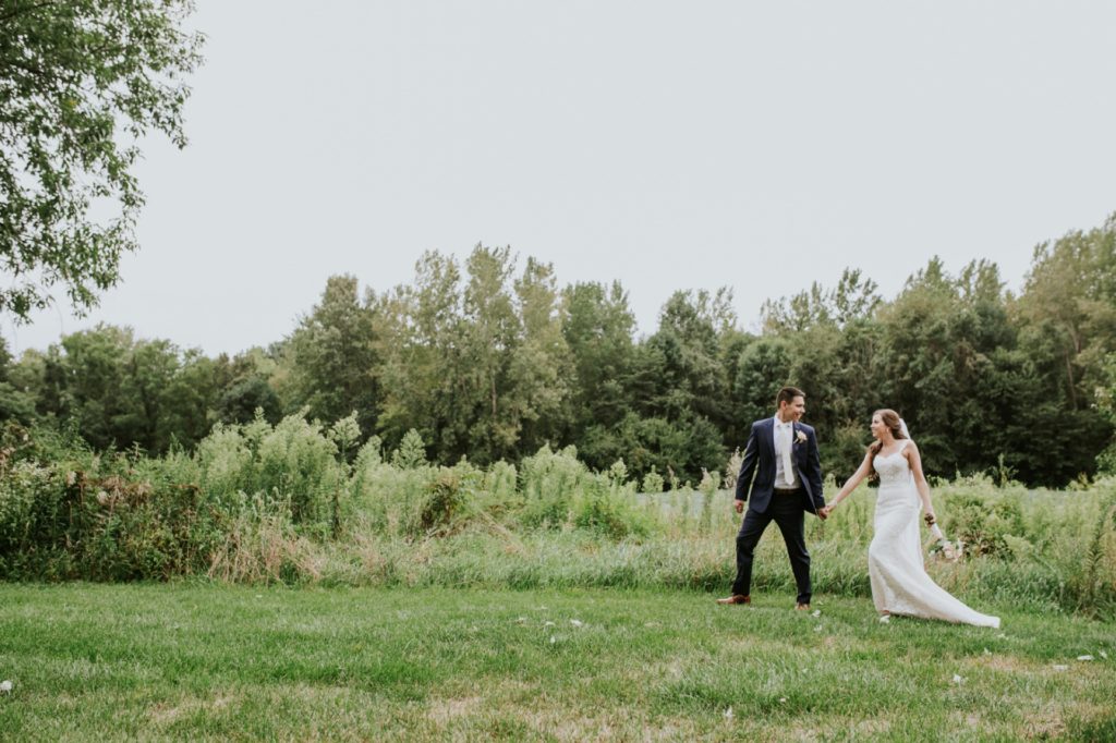 groom leads bride by hand while walking during their Noblesville Wedding Photography