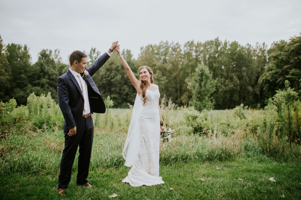 bride and groom hold hands high in the air during their Noblesville Wedding Photography