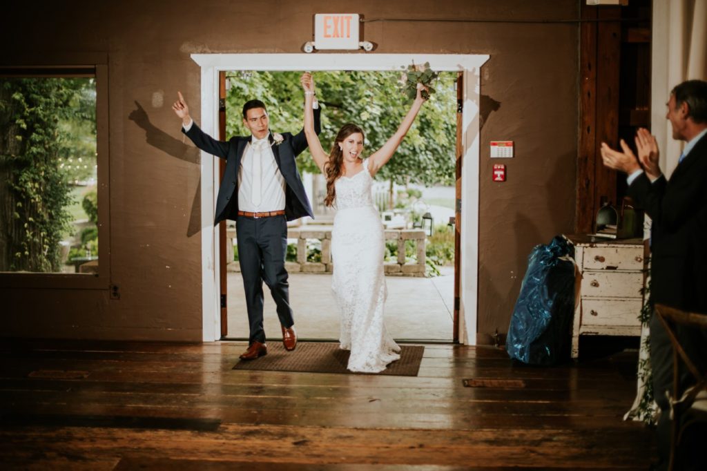 bride and groom enter barn for reception at mustard seed gardens