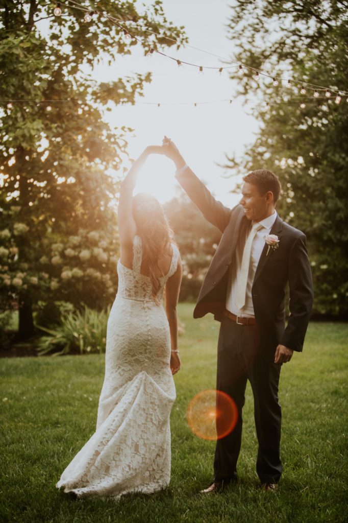 bride and groom dance at sunset with solar flare on the image for Noblesville Wedding Photography at mustard seed gardens