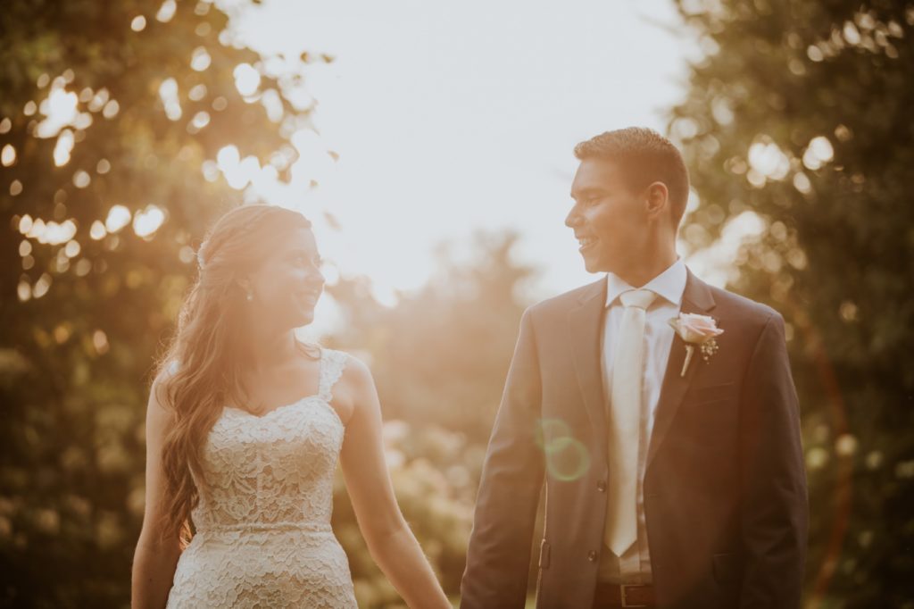 bride and groom hold hands and look at each other at sunset at mustard seed gardens for Noblesville Wedding Photography
