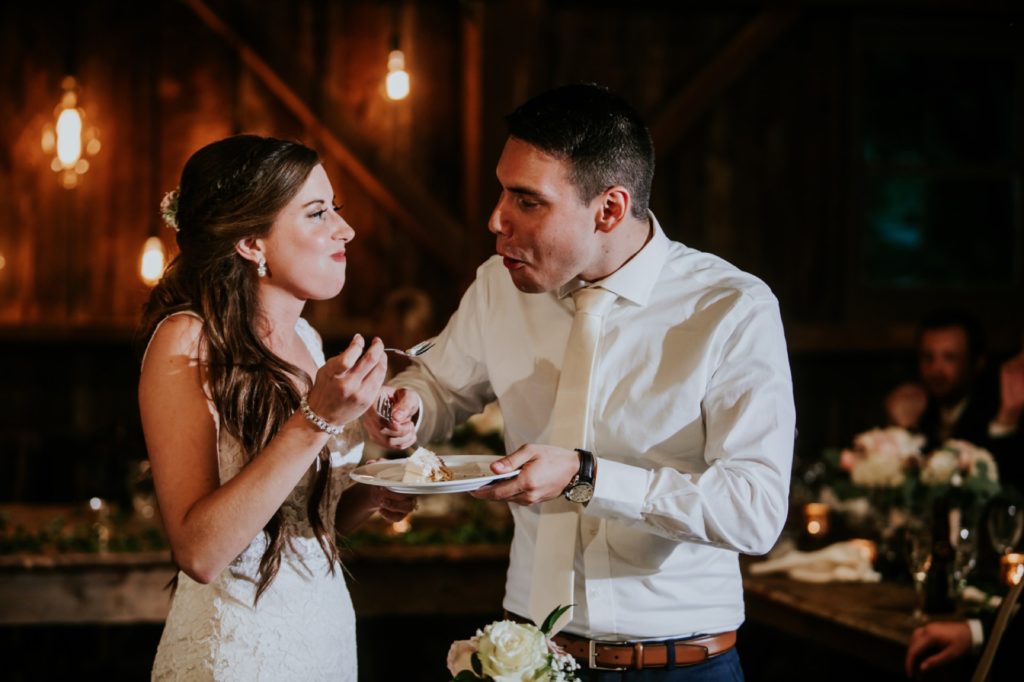 bride and groom eat cake at Noblesville Wedding Photography inside barn