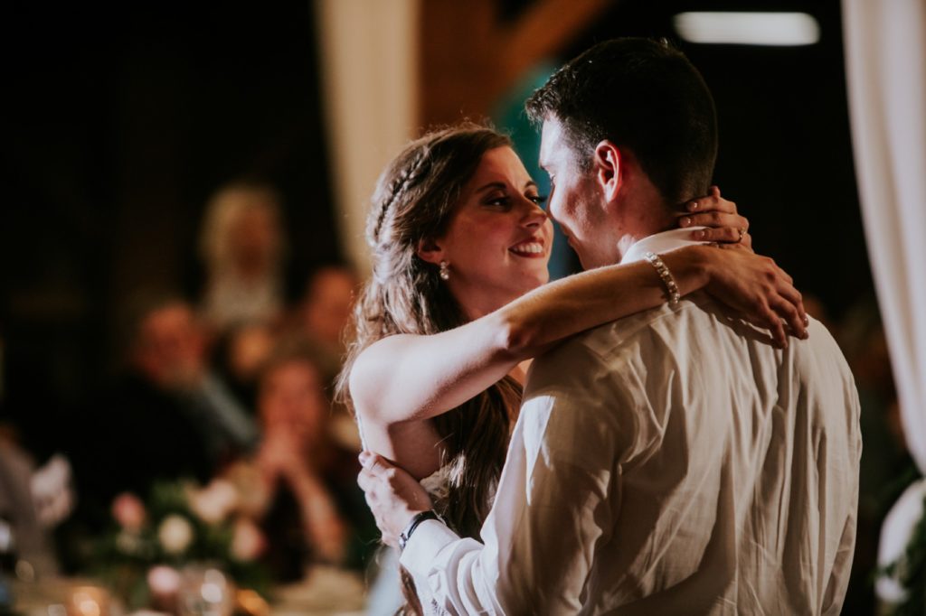 bride dances with arms wrapped around groom's neck for first dance for Noblesville Wedding Photography