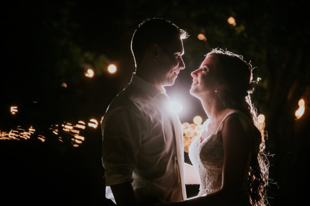 bride and groom smile as they look lovingly at each other outside at night for Noblesville Wedding Photography