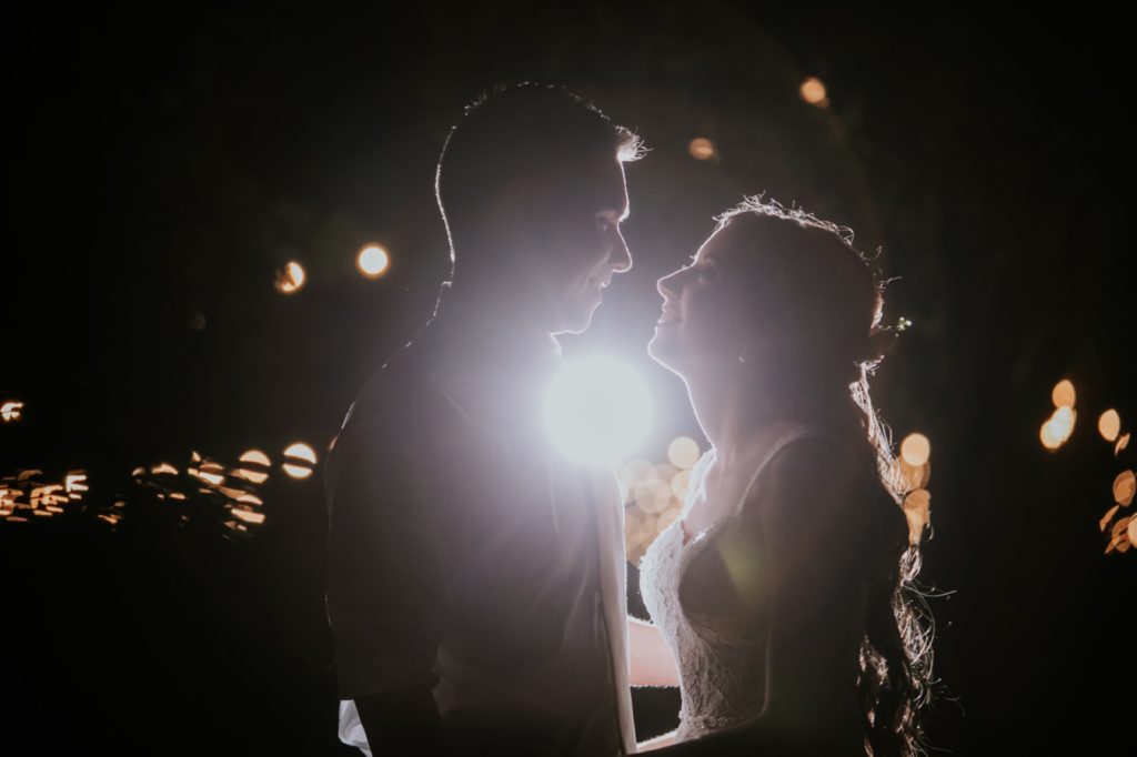 bride and groom backlit by off camera flash at night at mustard seed gardens for Noblesville Wedding Photography