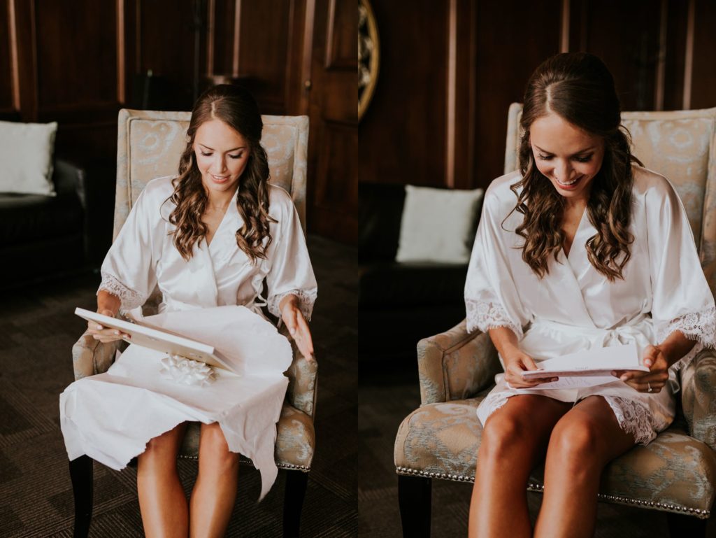 bride in robe opening wedding gift in downtown indianapolis wedding photography