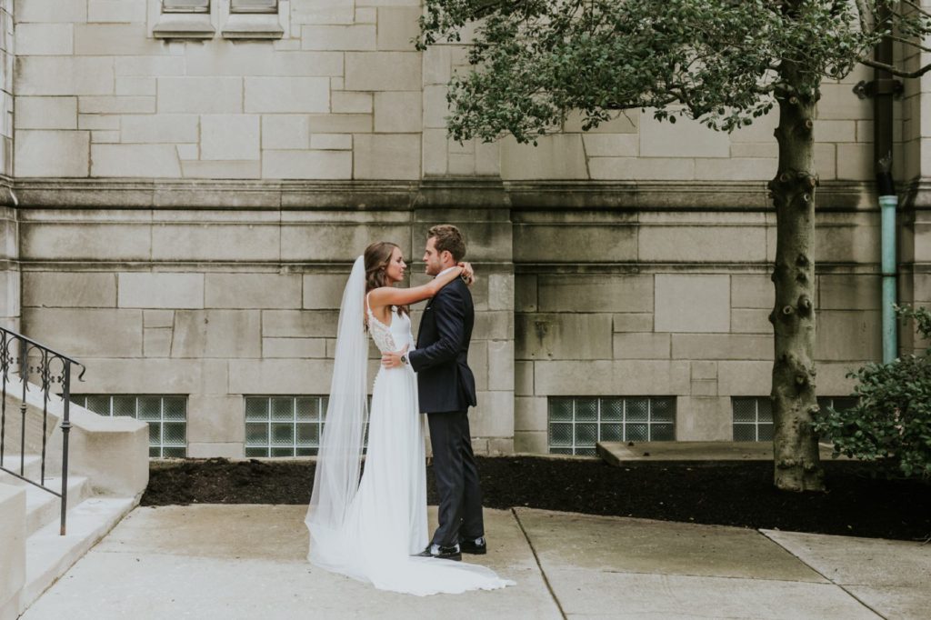 wide shot of bride and groom hugging at tabernacle presbyterian outside the building