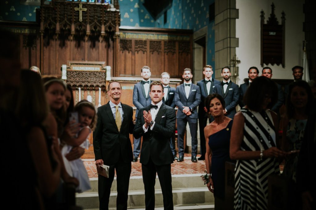 groom watches bride walk down aisle at tabernacle presbyterian church for wedding photography