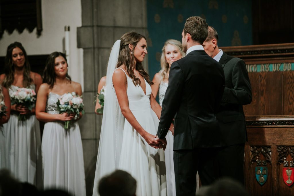 bride and groom smile and hold hands during tabernacle presbyterian church wedding photography