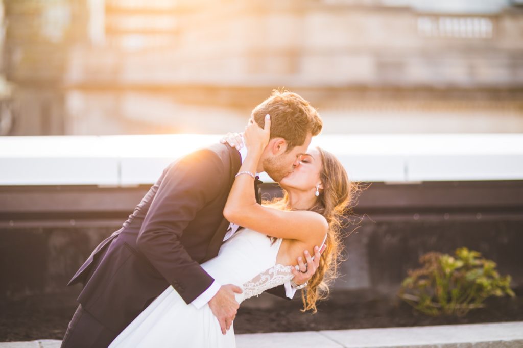 bride and groom kiss during Regions Tower wedding at sunset for their indy photographer