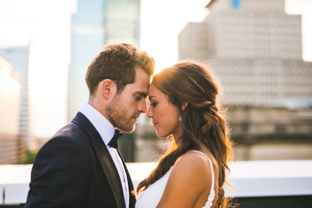 bride and groom press foreheads together at sunset during their Regions Tower wedding for Indianapolis photographer