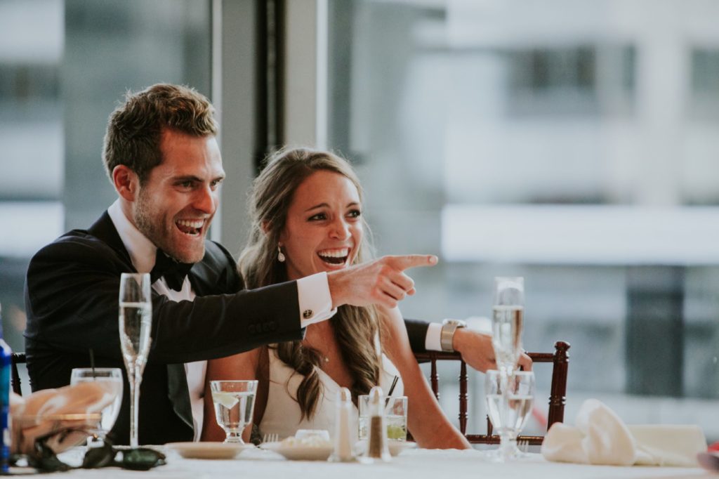 bride and groom point and laugh during reception at Regions Tower indianapolis photographer