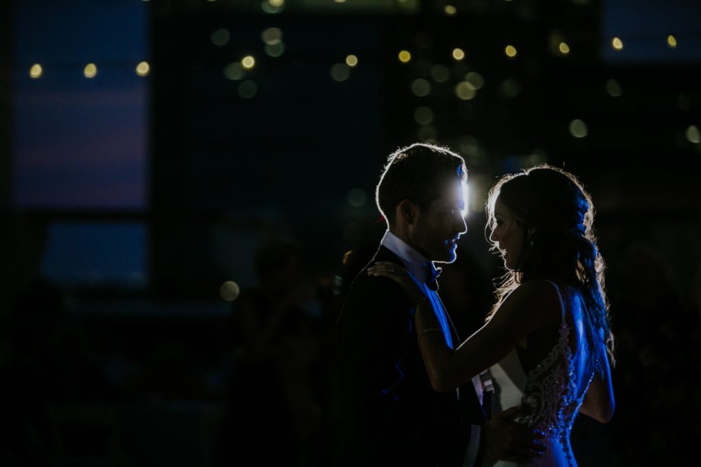 bride and groom dancing on rooftop backlit by off camera flash for Regions Tower wedding in Indianapolis photography
