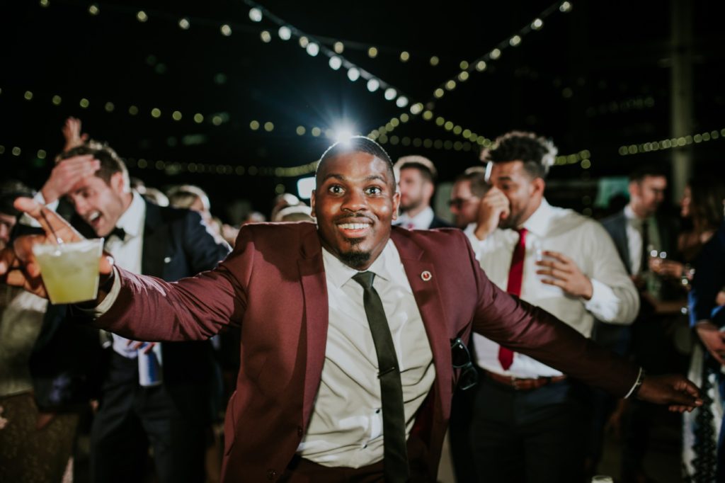 man in maroon suit dances during wedding reception for indianapolis photography