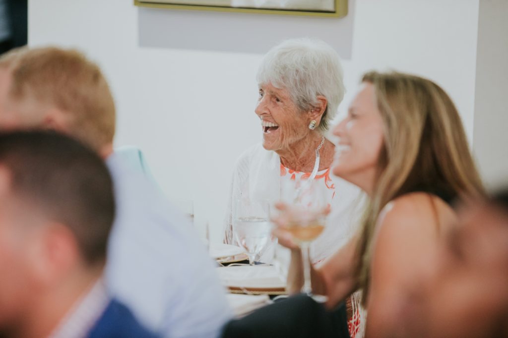 a woman with white hair laughs at a rehearsal dinner at Conrad Indianapolis Event Photography