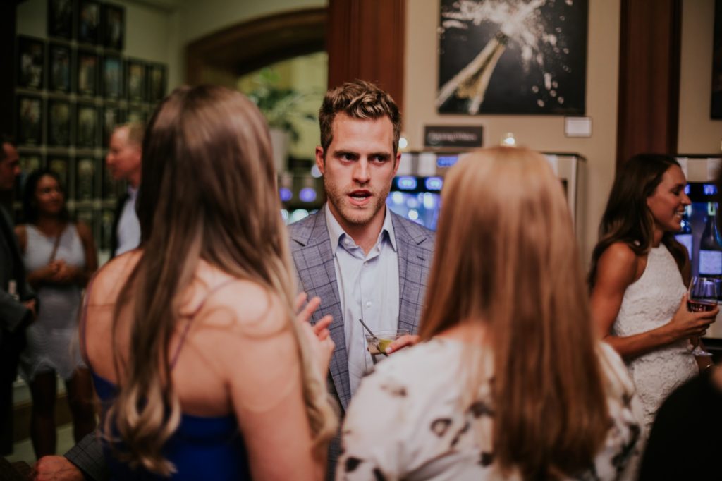 a man in a plaid suit talks to two women at Tastings Wine Bar and Bistro