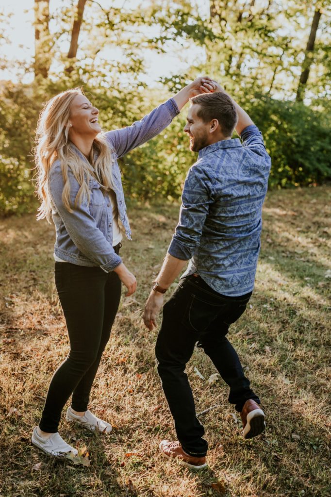 a man and a woman both laugh at the end of a spin during their Eagle Creek Engagement Photos