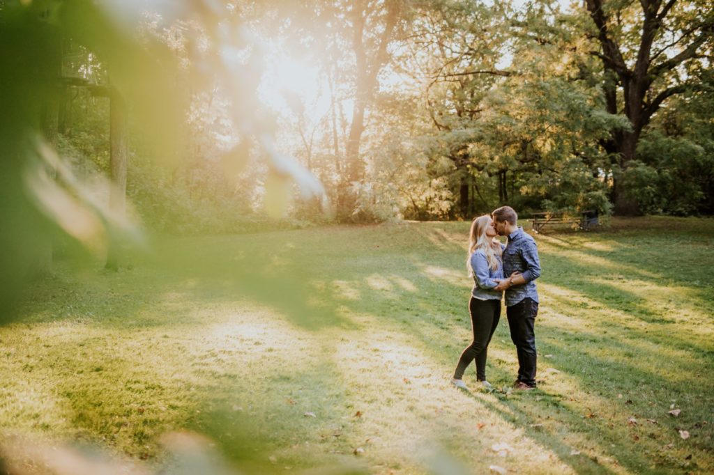 a man and woman kiss in speckled sunlight during their Eagle Creek Engagement Photos