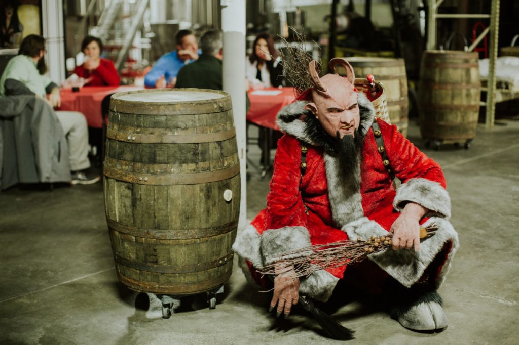 krampus squatting next to barrels during this Indianapolis Brewery Event Photography