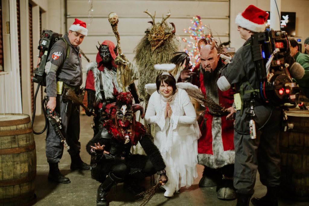 costumed party goers krampus, alien santa, ghostbusters, and angel pose for photos at this herst with scarlet lane brewing company logo on back at this Indianapolis Brewery Event Photography