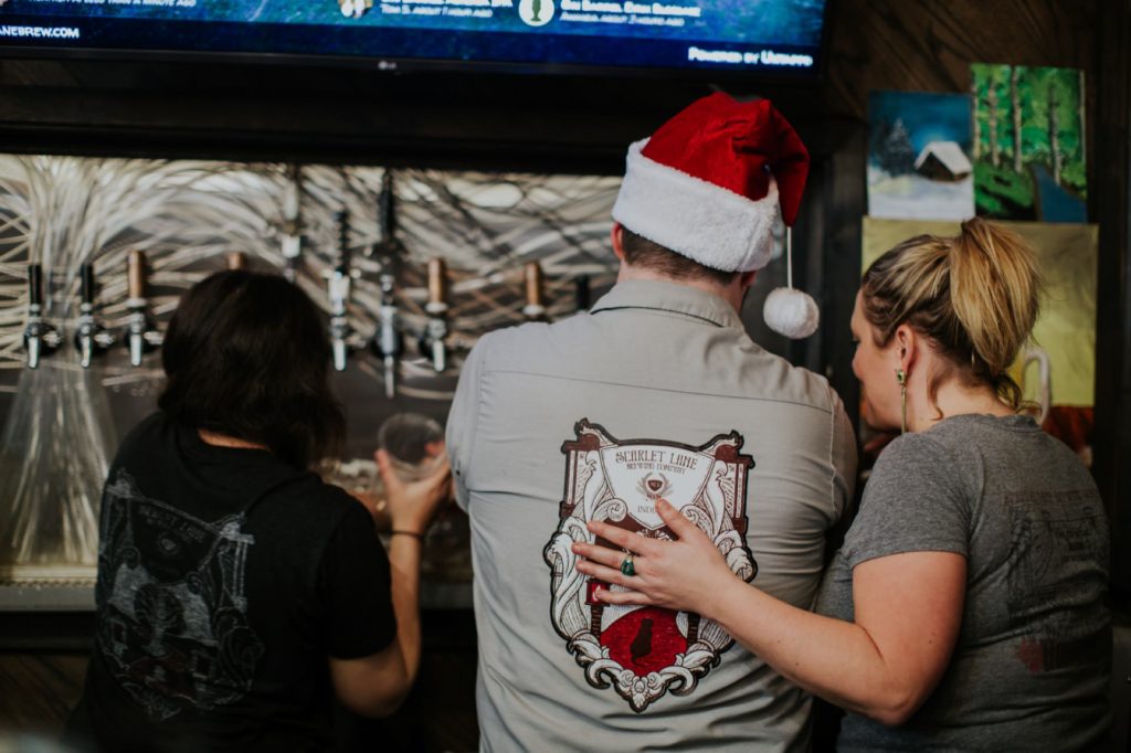 woman rests hand on man's back at scarlet lane brewing company