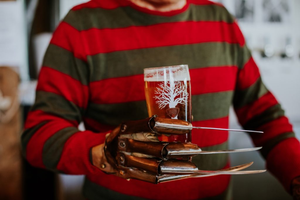 stripey sweater and claws hold a glass in this Indianapolis brewery photography