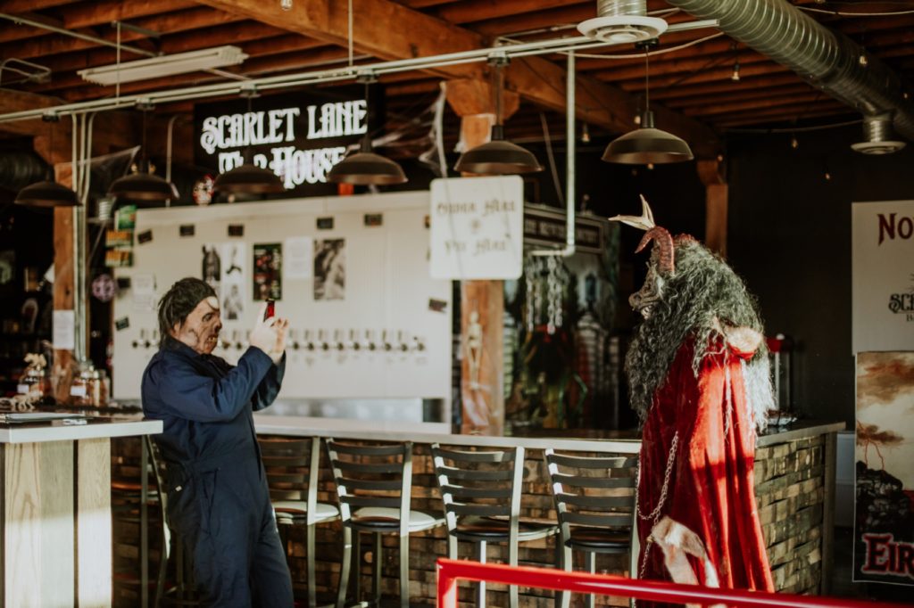 man in halloween costume takes picture of krampus at scarlet lane for this Indianapolis brewery photography