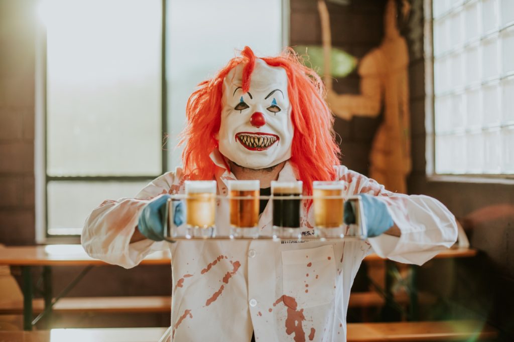 clown in lab coat holds flight of beer up in this Indianapolis brewery photography