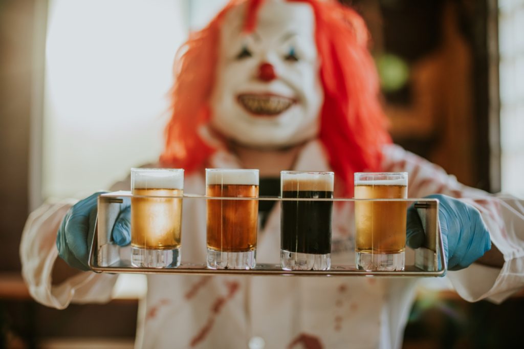 flight of beers being held up by clown for this Indianapolis brewery photography