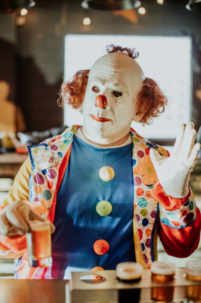 clown waves while drinking beer for this Indianapolis brewery photography