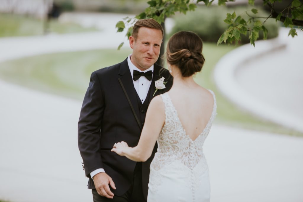 groom sees bride for first time during first look on indianapolis canal