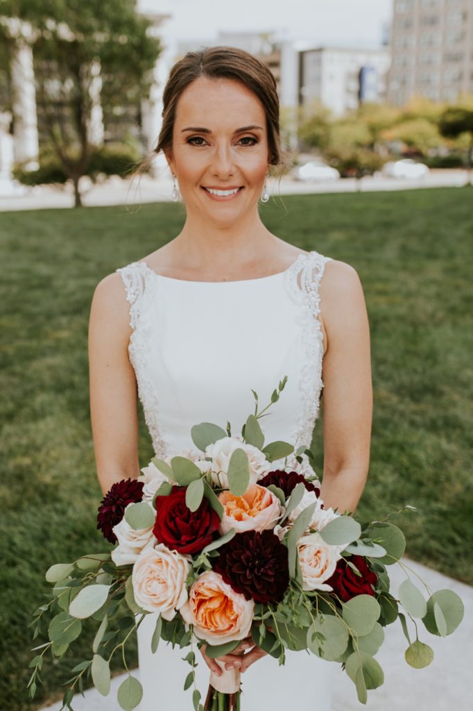 beautiful bride holding a dark autumnal bouquet