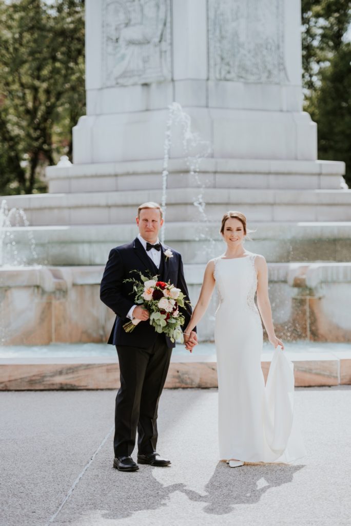 groom and shadow and bride in sunlight in front of fountain at obelisk square
