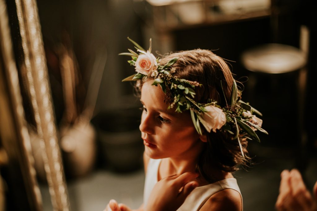 flower girl with flower crown getting ready in industrial wedding venue