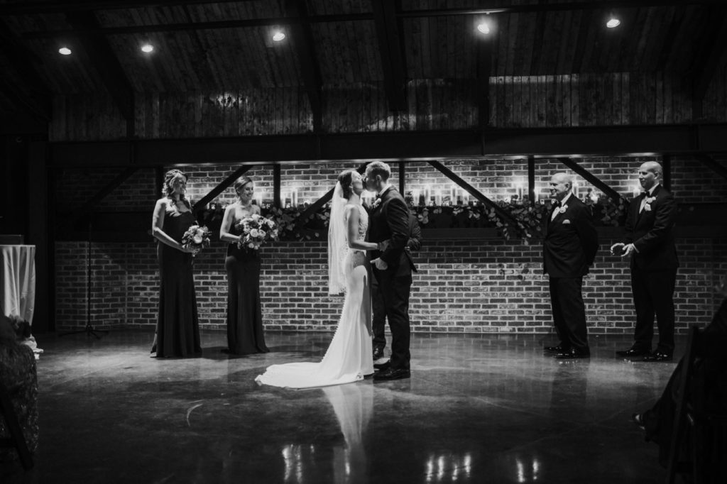 black and white photo of first kiss during a canal 337 wedding