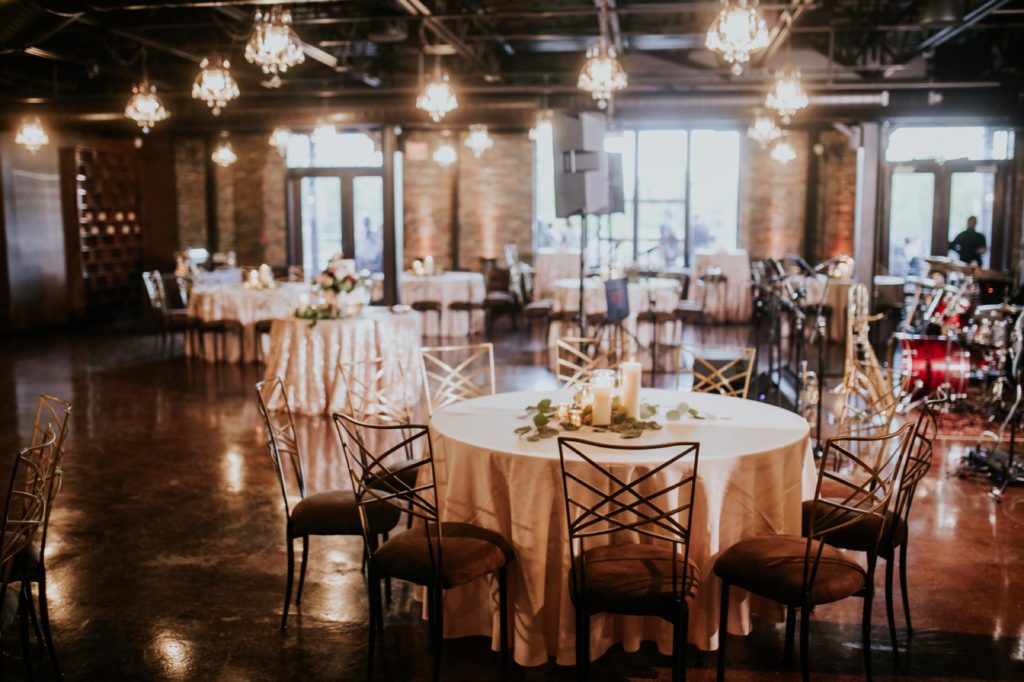 tables lit by window light with floor length linens at canal 337 wedding