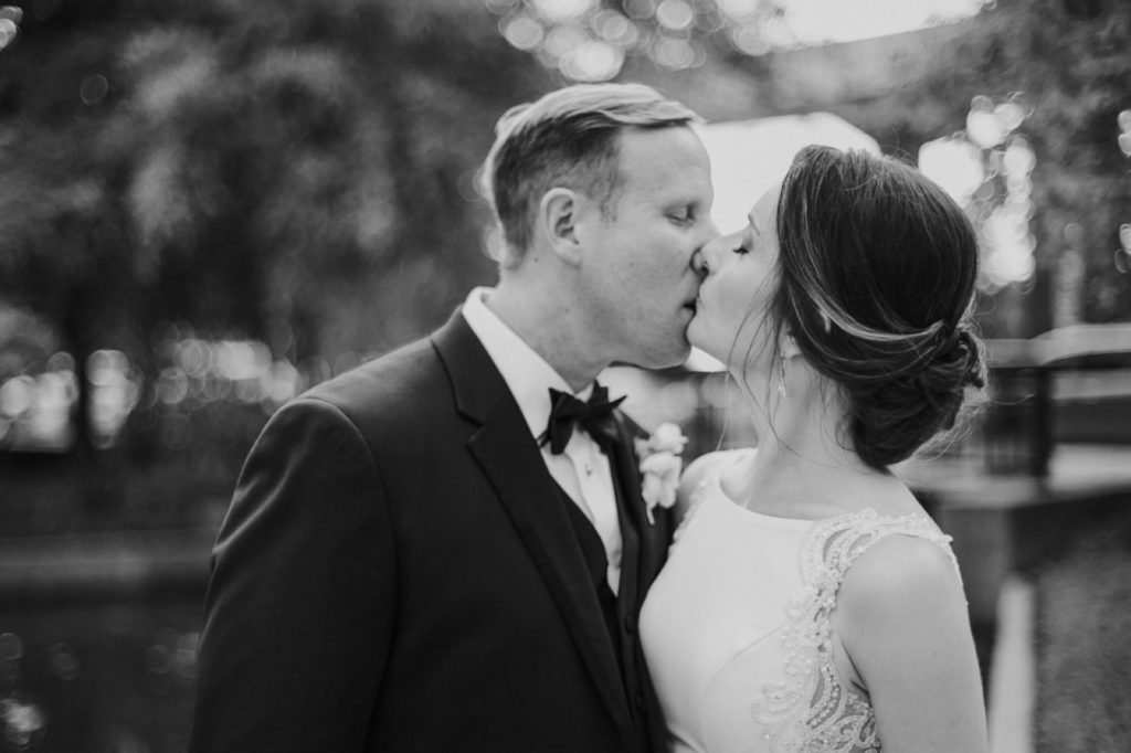 bride and groom kiss at sunset in black and white photo at canal 337 wedding