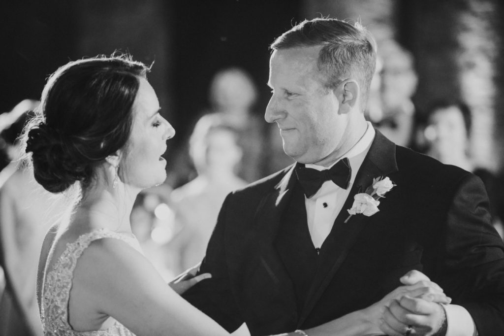 black and white photo of bride and groom dancing for the very first time at their canal 337 wedding in indianapolis