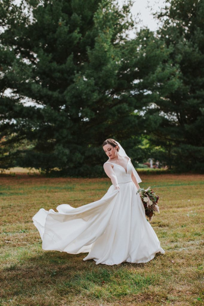 bride swishing her dress around her in jackson morrow park before her Bel Air Kokomo Wedding