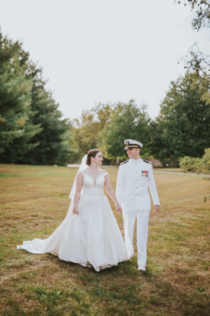bride and groom walk holding hands in jackson morrow park in kokomo
