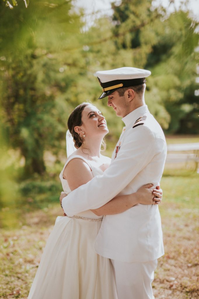 bride hugs groom in navy full dress whites in jackson morrow park in kokomo